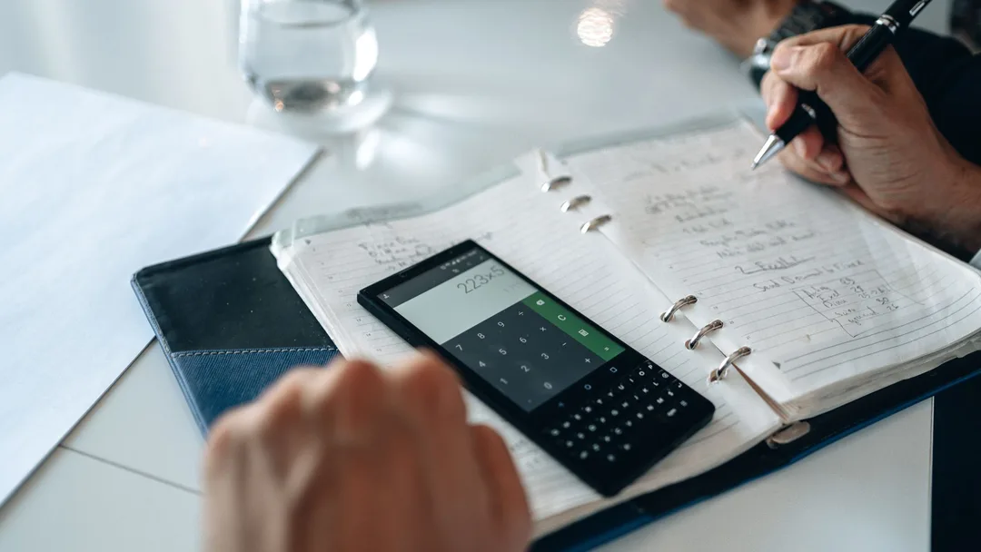 Calculadora e caderno numa mesa de planejamento