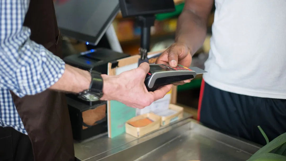 Cliente pagando com cartão no balcão da loja
